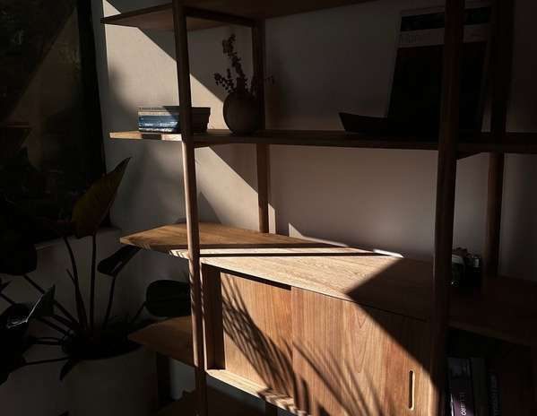 Biblioteca en roble macizo bañada por luz lateral — La Fragua Taller